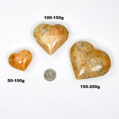 orchid calcite hearts next to a quarter for size reference 