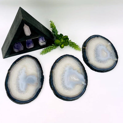 Three agate slices with dark banding and white and gray on a white background.