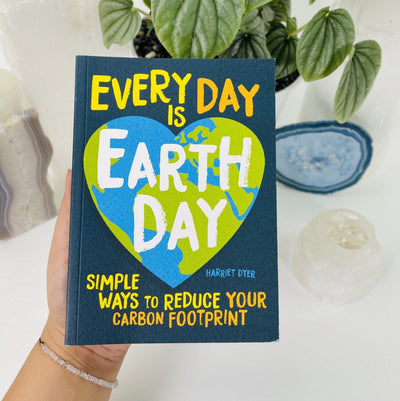 A book of Everyday is Earth Day by Harriet Dyer in hand.