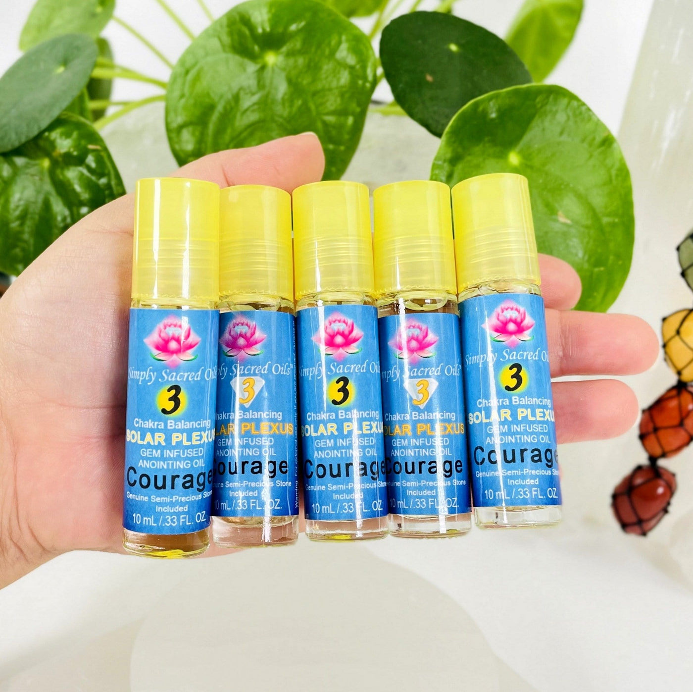 multiple Simply Sacred Oil -  Solar Plexus Chakra Balancing Oil bottles in hand for size reference