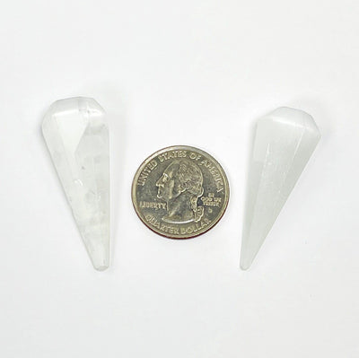 selenite pendulum points with quarter for size reference 