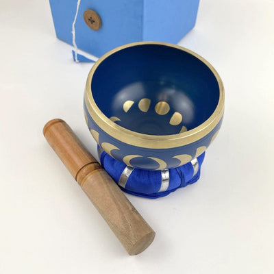 top view of Blue singing bowl showing inside of bowl moon phase design and mallot beside it