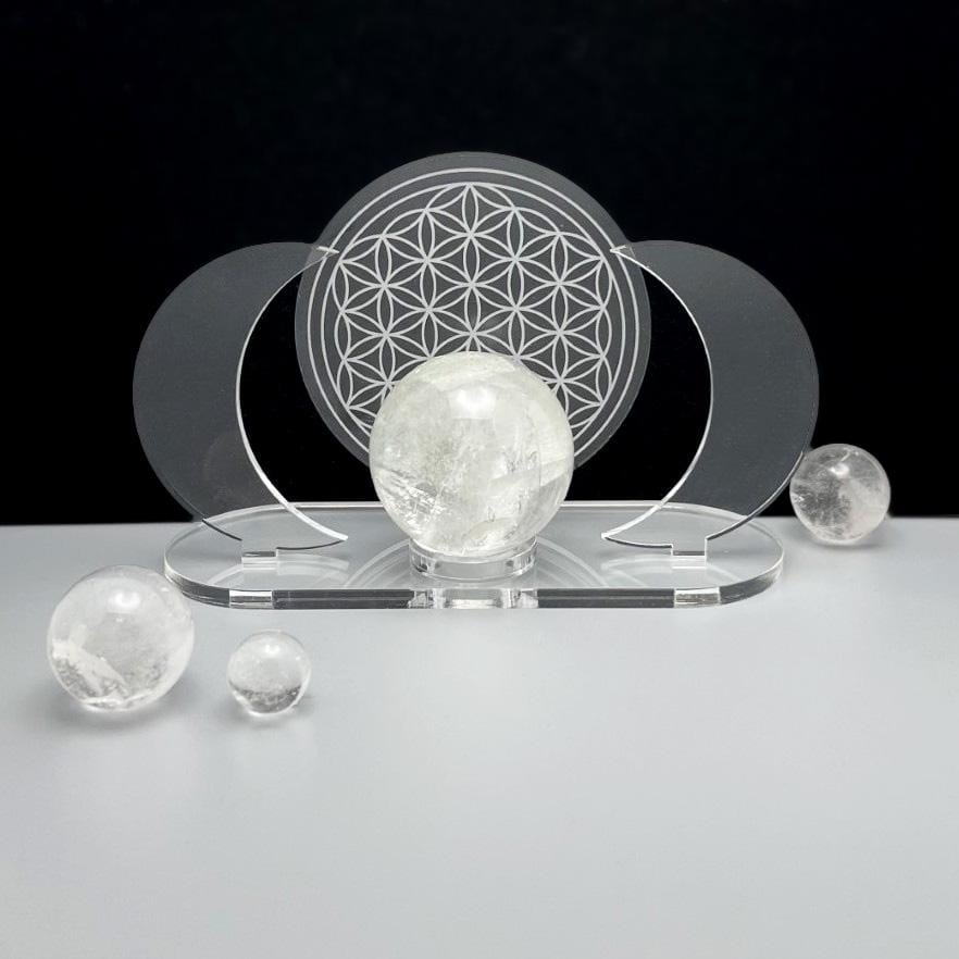 Acrylic Sphere Holder - Crescent Moons with Flower of Life shown holding a sphere with crystals surrounding.