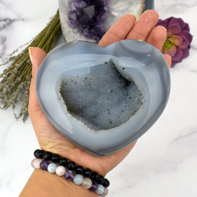 Close up of Agate Druzy Heart - OOAK - (DOOAK-S24-06) in a hand within an alter.