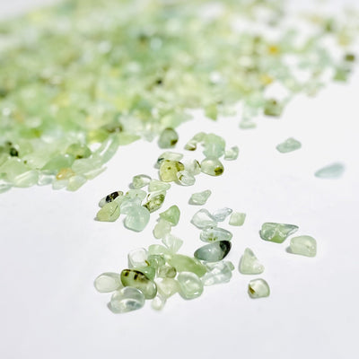 close up green prehnite chips on a white background
