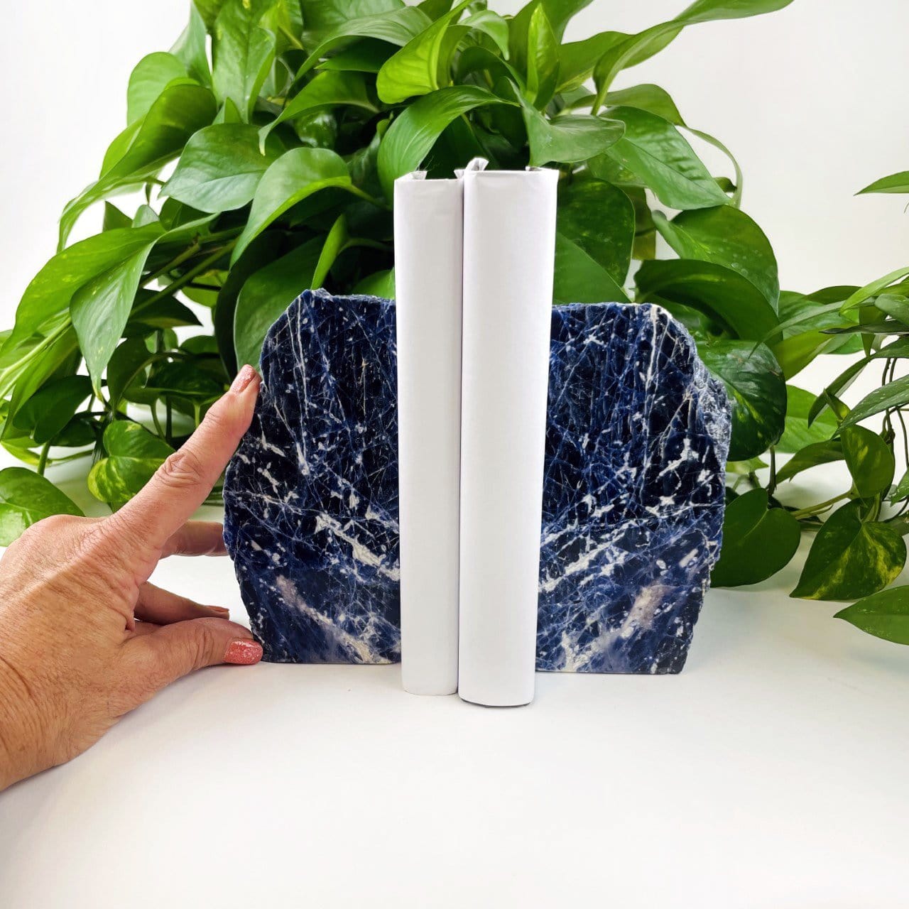 Sodalite bookend displayed with hand next to it for size reference 