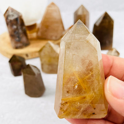 Rutilated Quartz Point in hand for size reference 