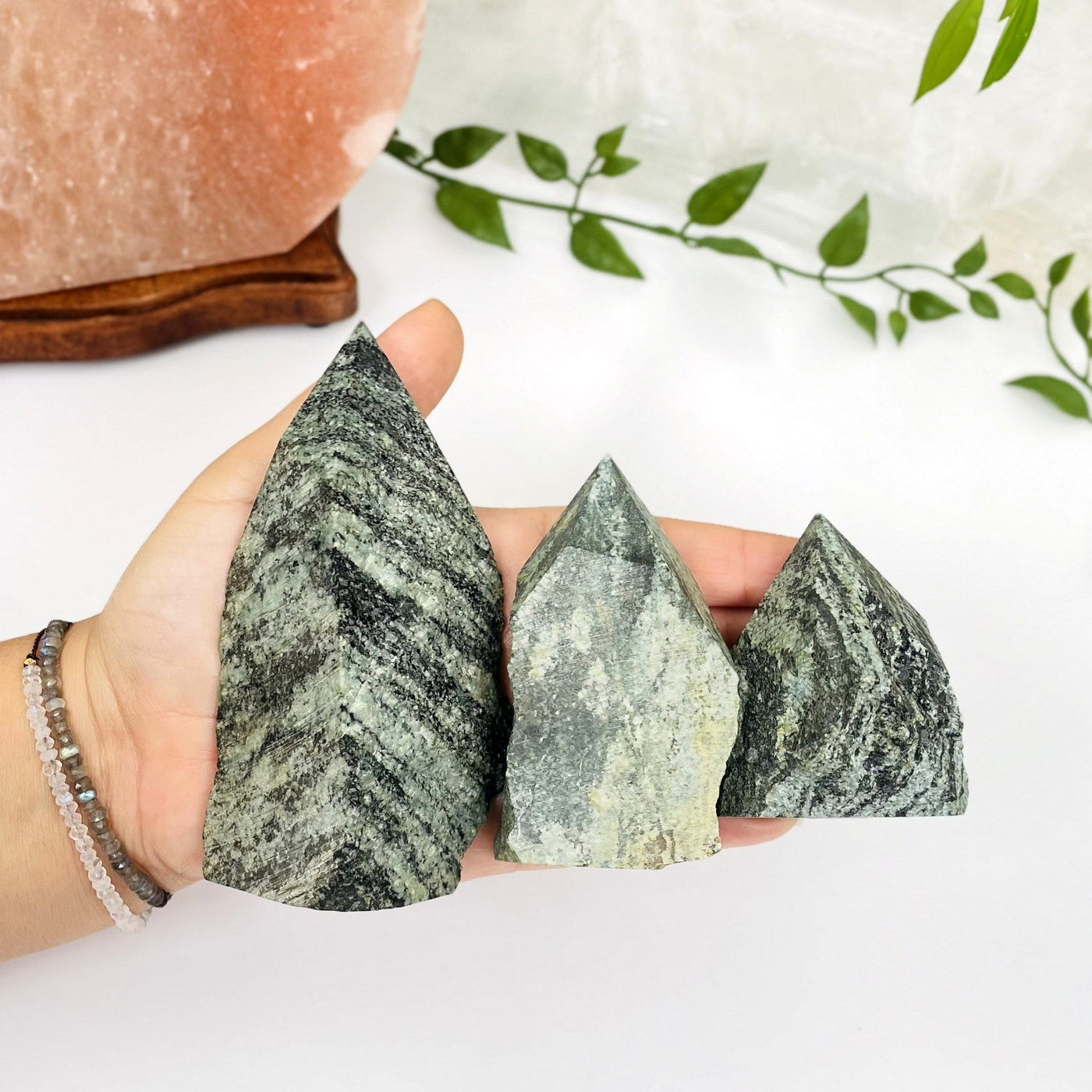 green snakeskin jasper points in hand for size reference
