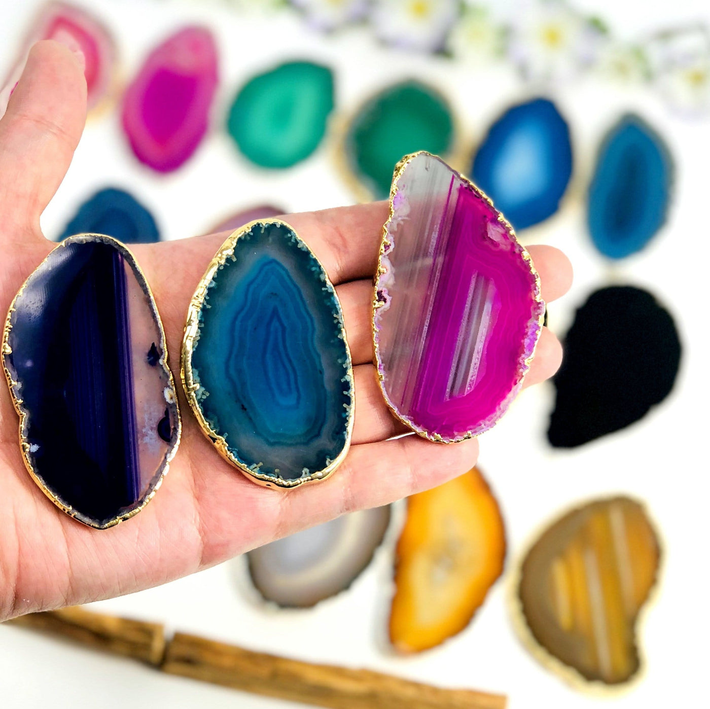 Picture of one of our purple, blue, and pink agate slices in hand for size reference. 