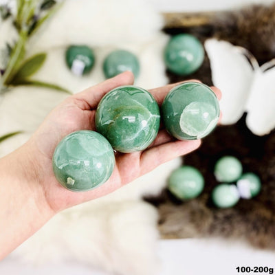 Green Aventurine Polishspheres in hand for size reference. showing the 100-200g sizeed Spheres - By Weight (SPHE-S1)
