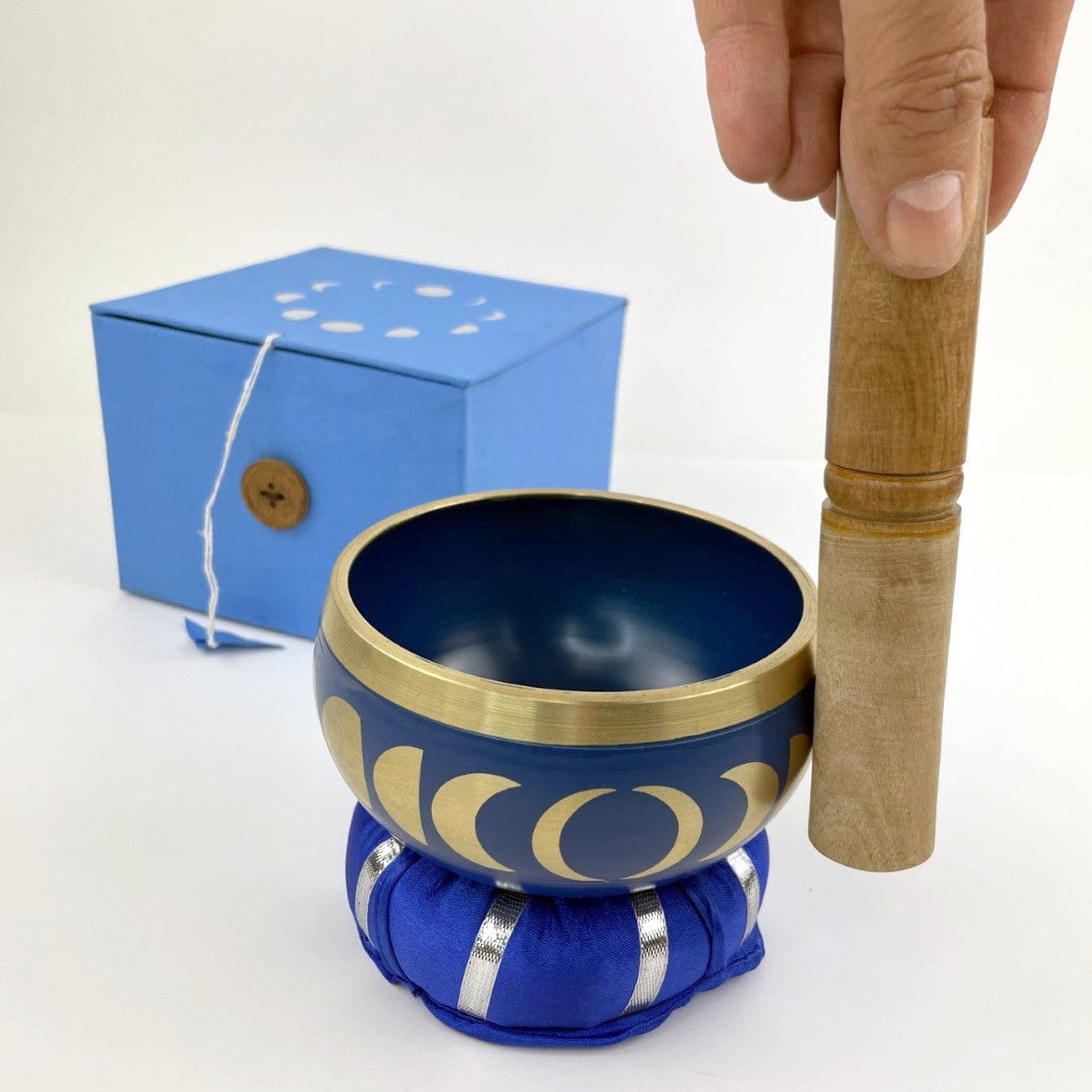 blue singing bowl with mallot on edge showing in use. with blue box behind