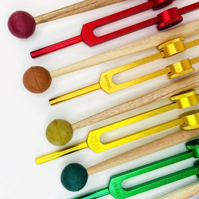 Close up of the Green, Yellow, Orange and Red Tuning Fork and Mallet