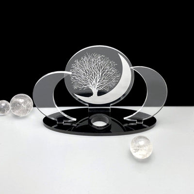 Sphere holder with a cut out acrylic circle in the middle that has an engraved tree and moon.  Two clear acrylic moons on the side and a black base. 