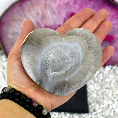 Picture of the front side of the agate polished heart in hand.