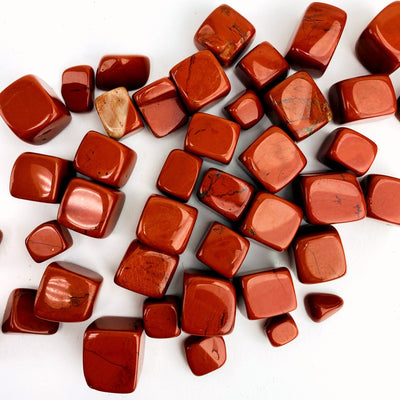 Red Jasper Cubed Tumbled Stones scattered across white background