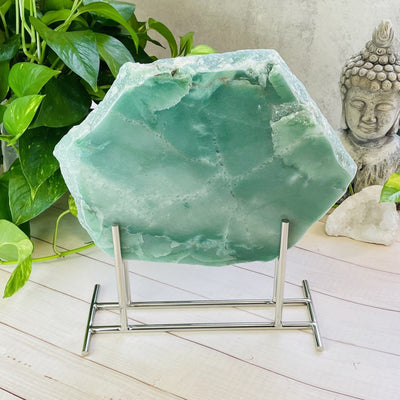 Display Stand Silver Color With Aventurine Platter on Wooden Background.