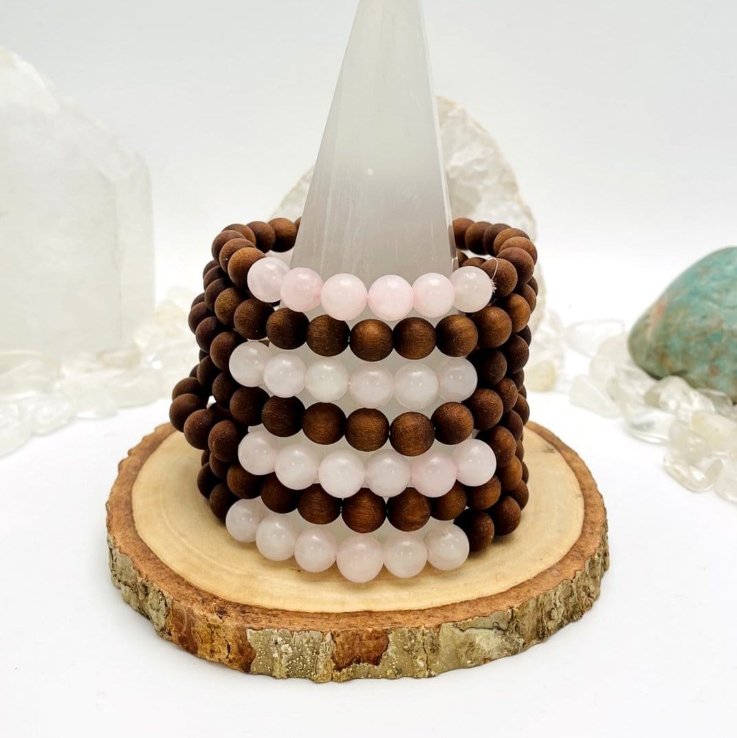 sandalwood bead bracelets with rose quartz on display for possible variations