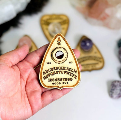 Hand holding the Planchette Light Wooden Sphere Stand