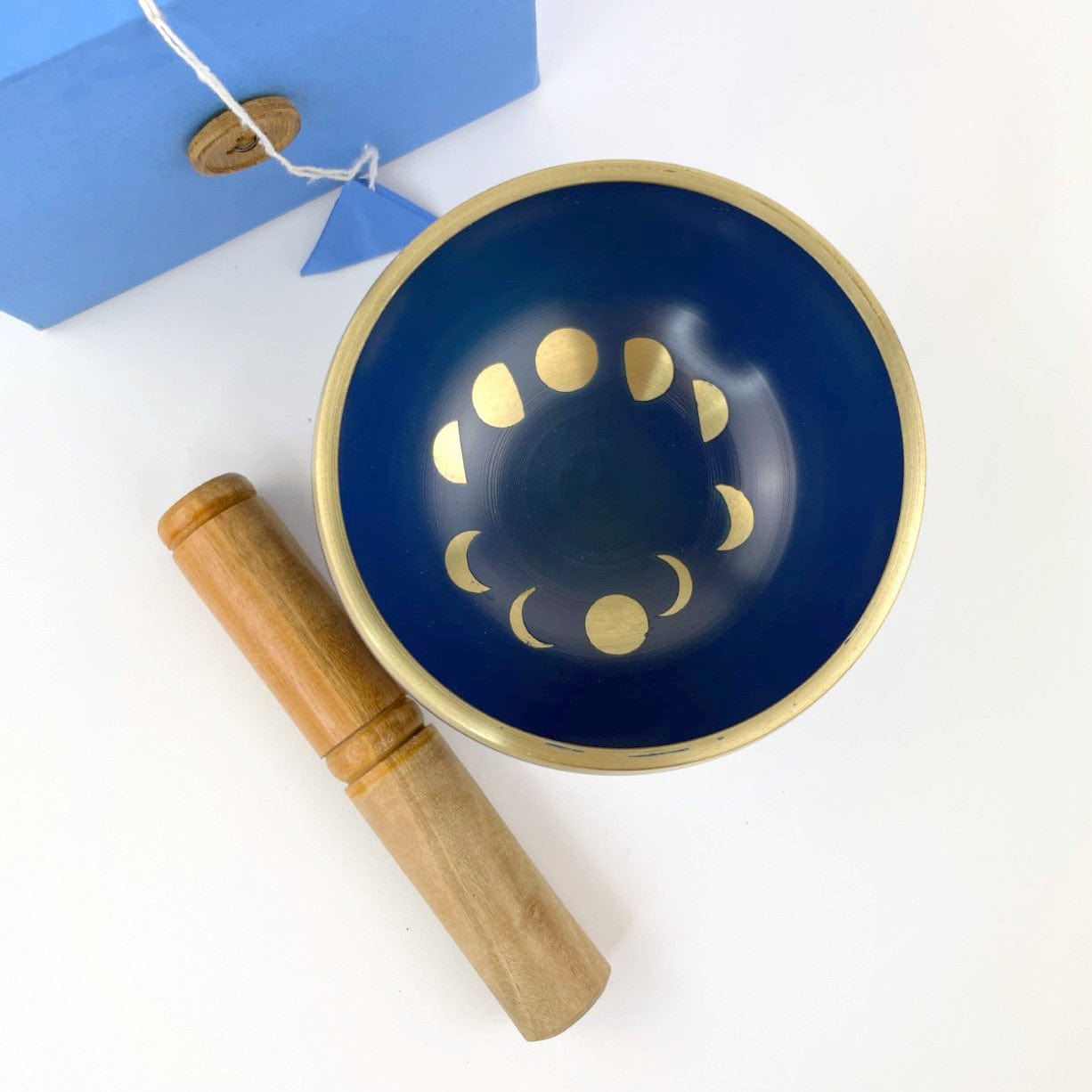 top view of blue singing bowl with moon phase design in gold.
