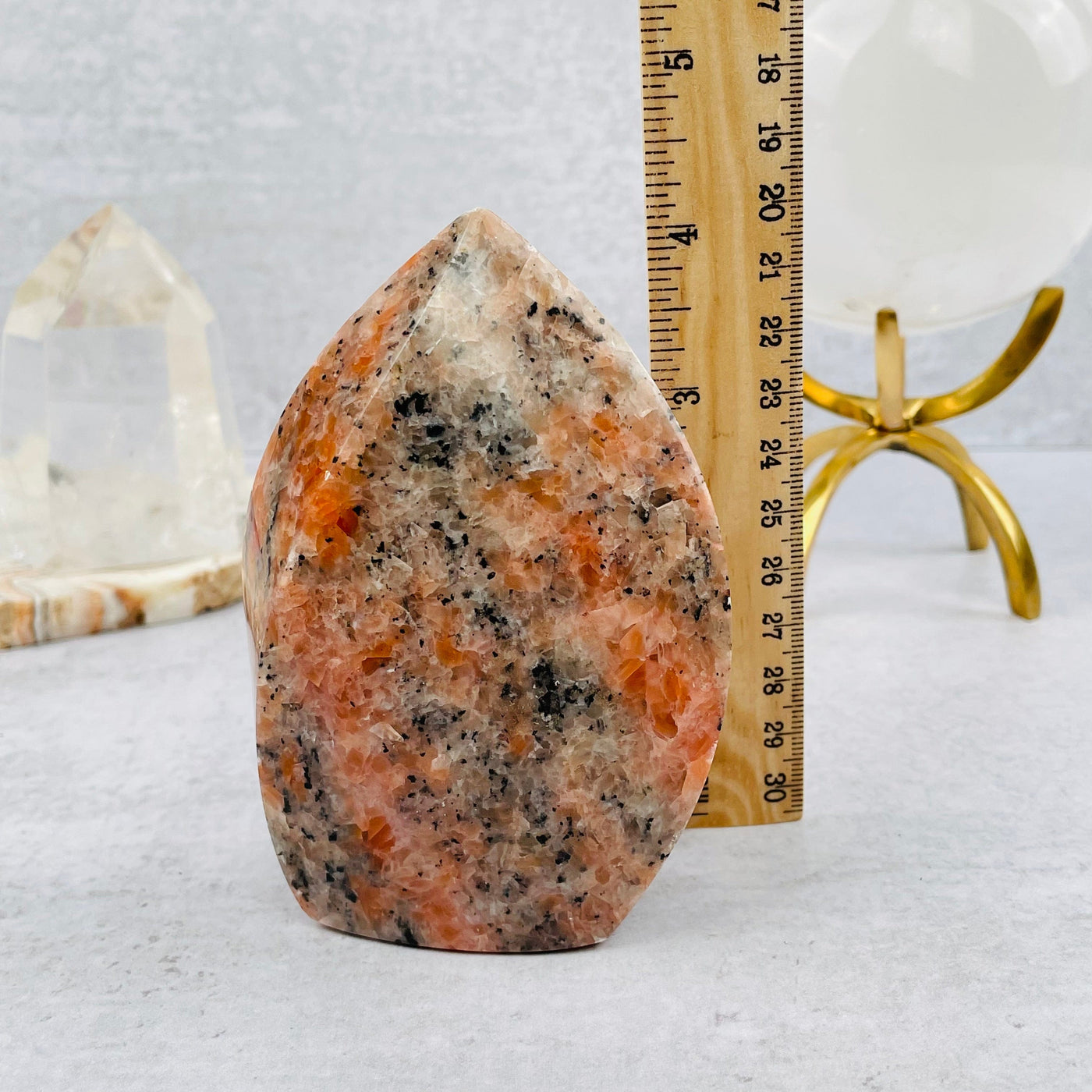 orchid calcite flame tower next to a ruler for size reference 