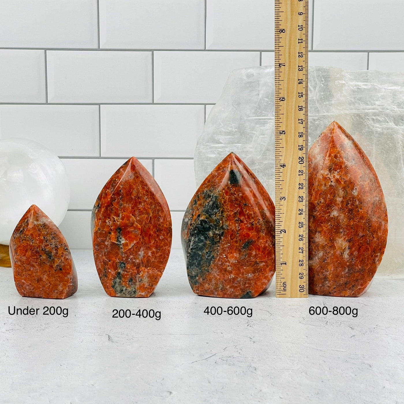 Orange Calcite Flame Points sold by weight. Displayed next to a ruler for size reference 