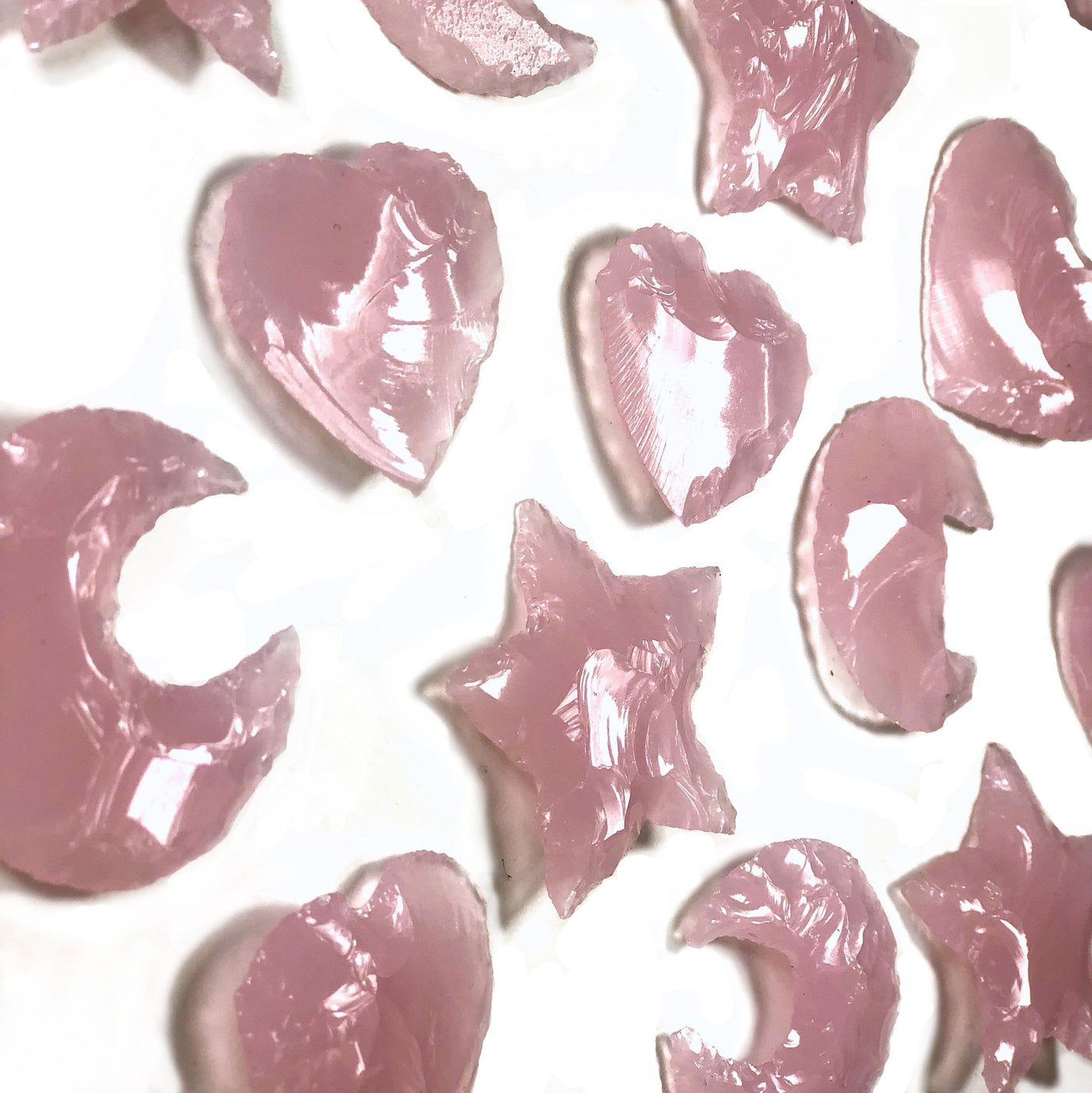 side view of Rose Quartz Colored Glass Hearts Moons and Stars on white background