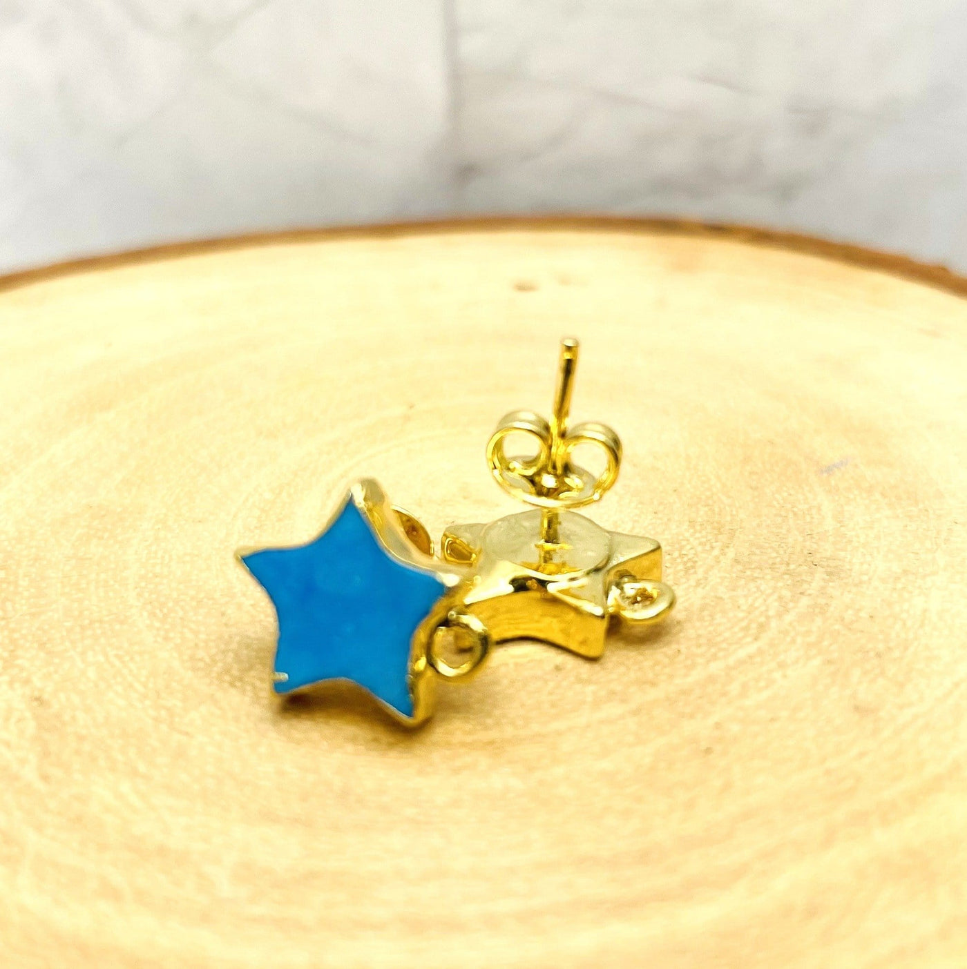 up close shot of blue and gold howlite stud earrings on wood background