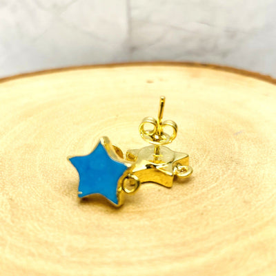 up close shot of blue and gold howlite stud earrings on wood background