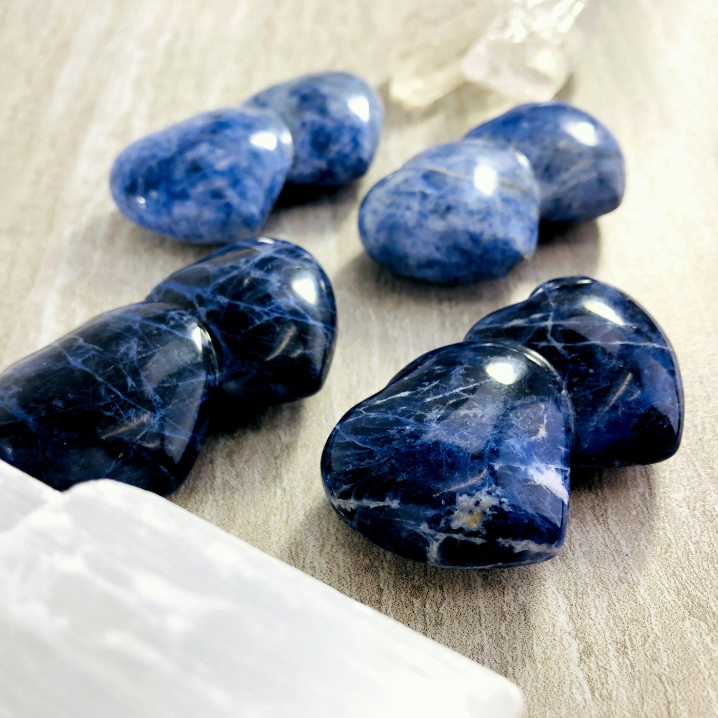 angled view of four sodalite double heart shaped stones for thickness