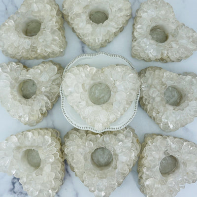 Heart shaped candle holder that is made with crystal quartz tumbled stones that are glued together.  This photo shows 9 candle holders.
