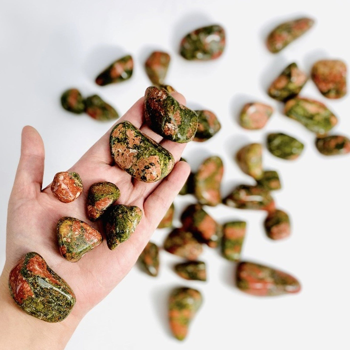 7 Unakite Tumbled Stones in hand to show size 