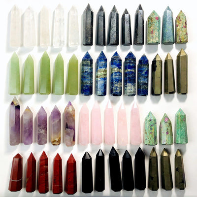 Various different colored Gemstone Pencil Polished Points displayed on a flat surface
