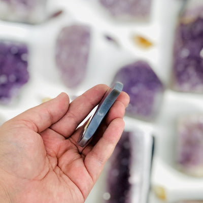 Large Amethyst Half Moon displayed in hand side view for thickness reference
