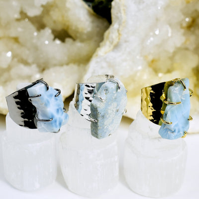 angled shot of different metal Larimar Rings with decorations in the background