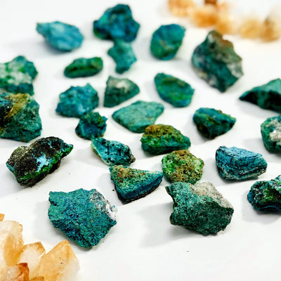 Many Azurite Mineral Stones spread out on a table showing colors, sizes and shapes from a side view showing thickness