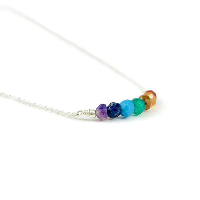 close up of the chakra crystal beads in the silver chained necklace 