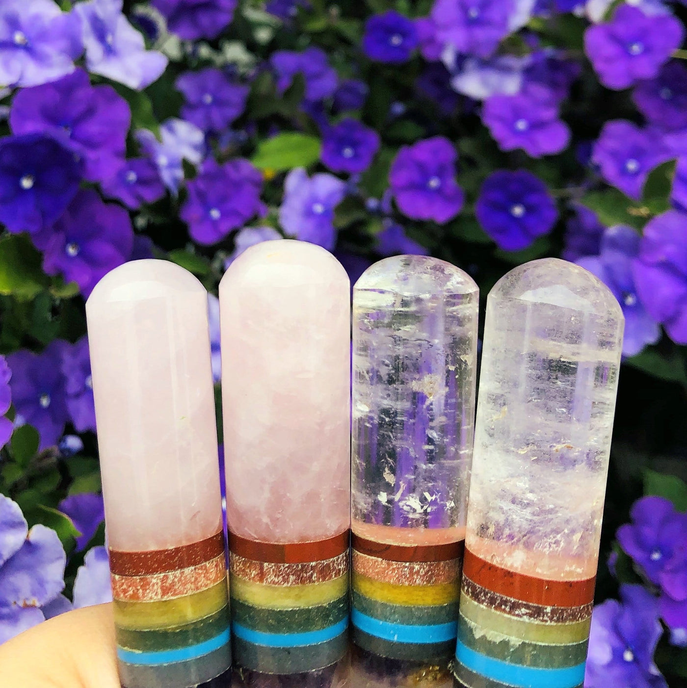 close up of four seven chakra polished wands (two in rose quartz and two in crystal quartz) for details and possible variations
