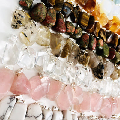 Up close view of Tumbled Gemstone Extra Grade Pendants, various colors displayed