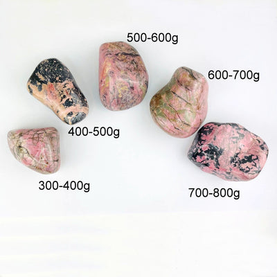 Rhodonite Tumbled Polished Stones in different sizes and weights on white background
