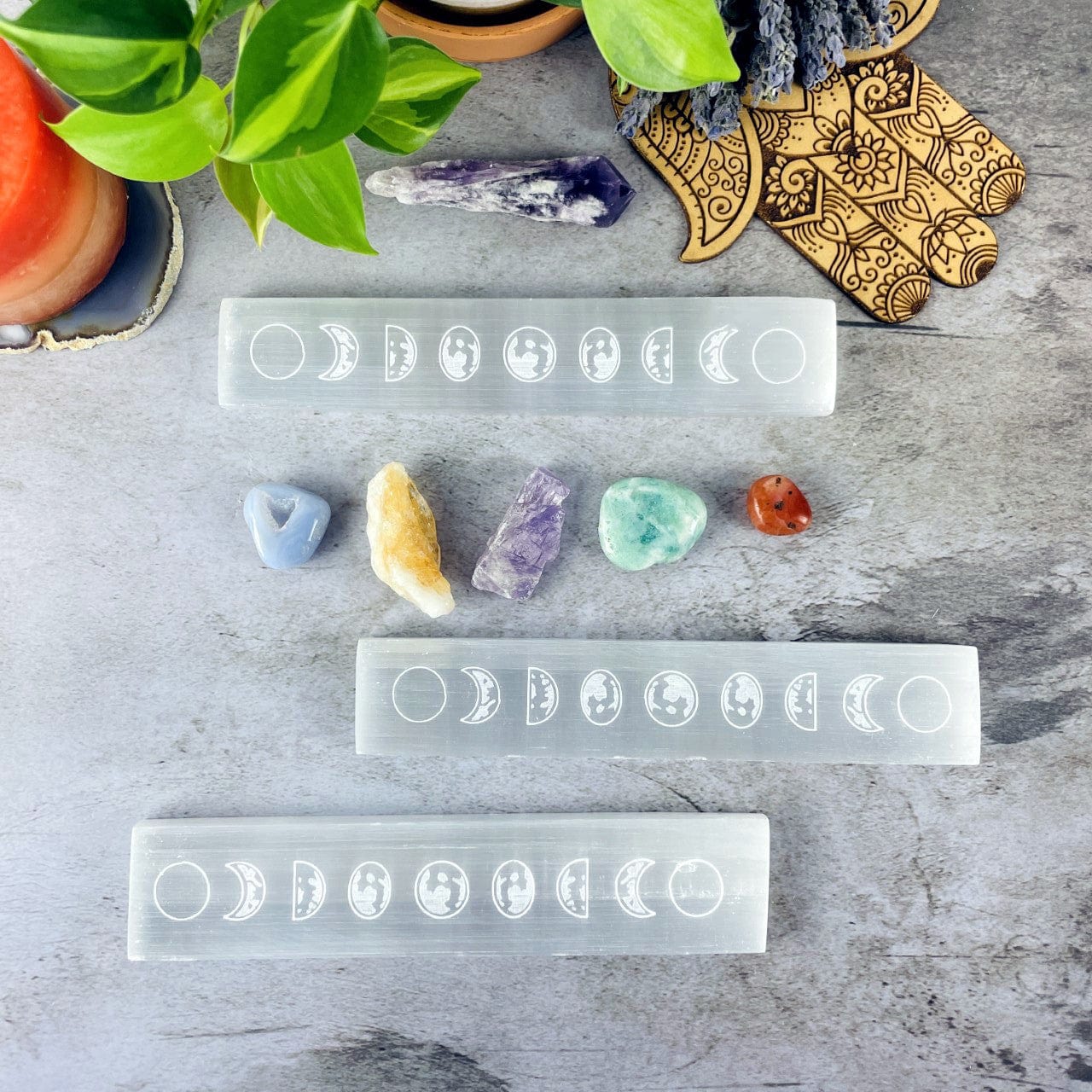 3 Selenite Charging Plates Engraved with Moon Phase Design with stones and other decor around