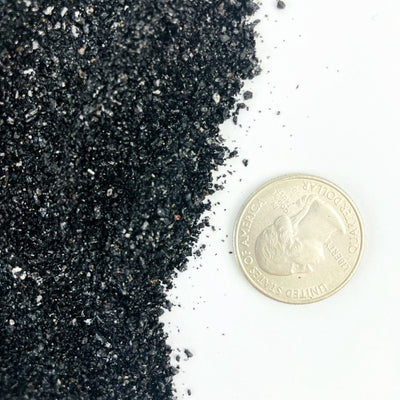 Tourmaline Dust next to a quarter for size reference