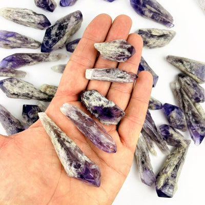 Elestial Amethyst Point - 1 Pound Bag with a sampling of points in a hand for size reference