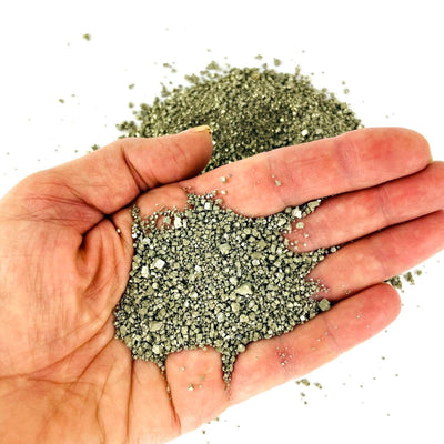 Pyrite Dust pictured in the palm of a woman's hand.