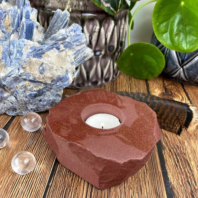 Rough stone candle holder with decorations in the background