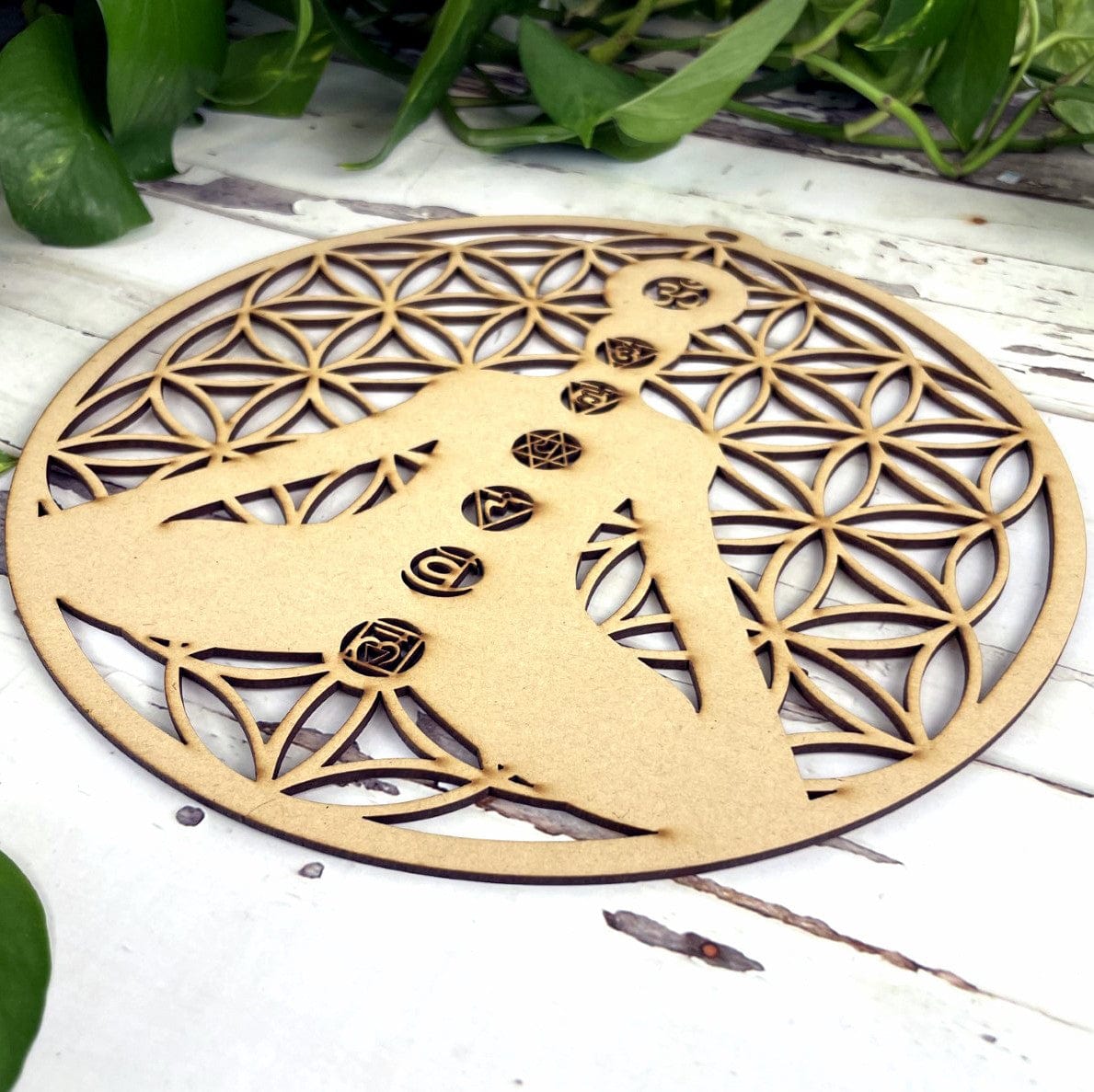 side view of Wood Crystal Grid with Flower of Life Cut outs and a cut out of a person sitting in meditation pose.