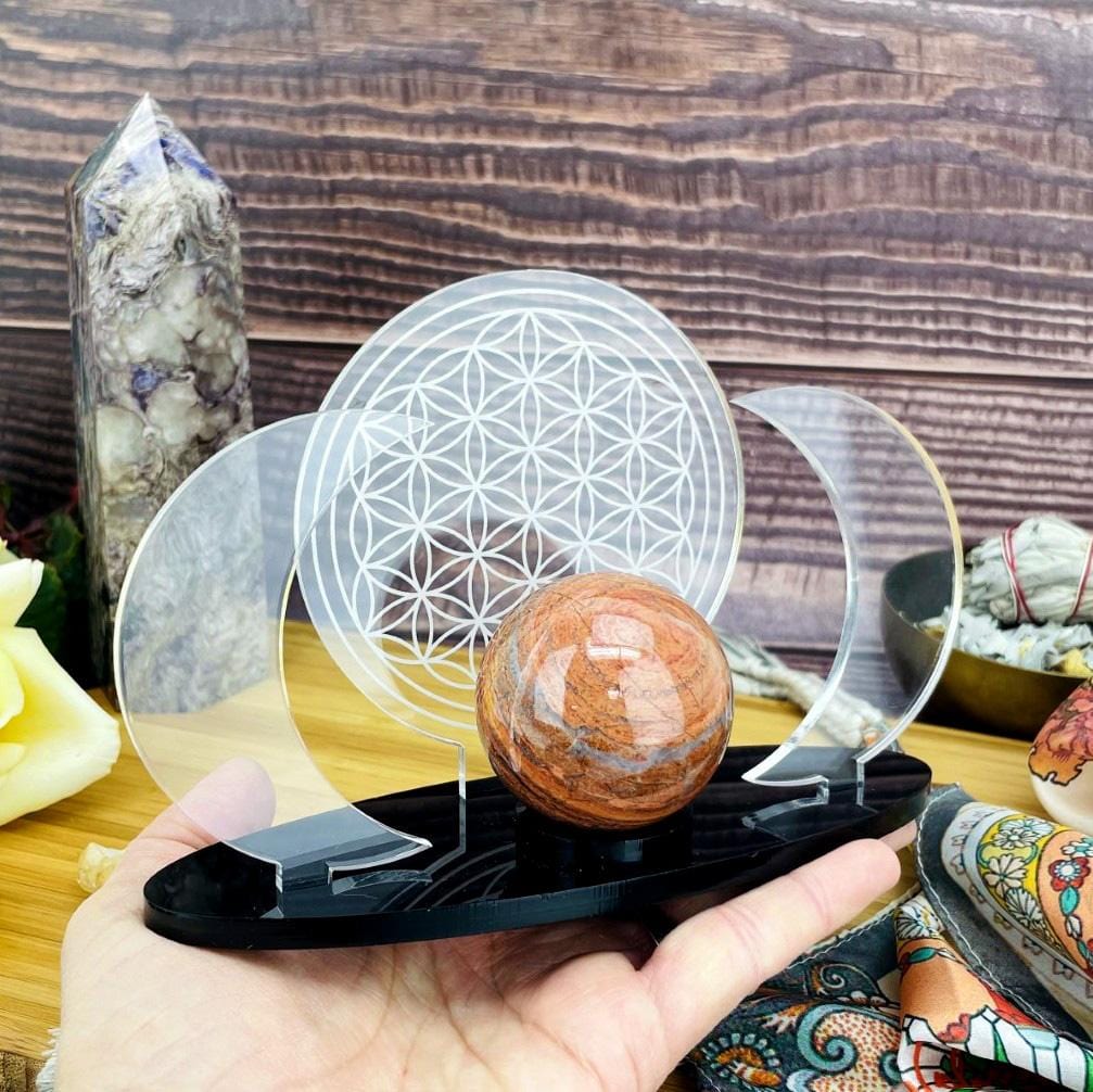 Acrylic Sphere Holder Crescent Moons with Flower of Life holding a sphere in a hand.