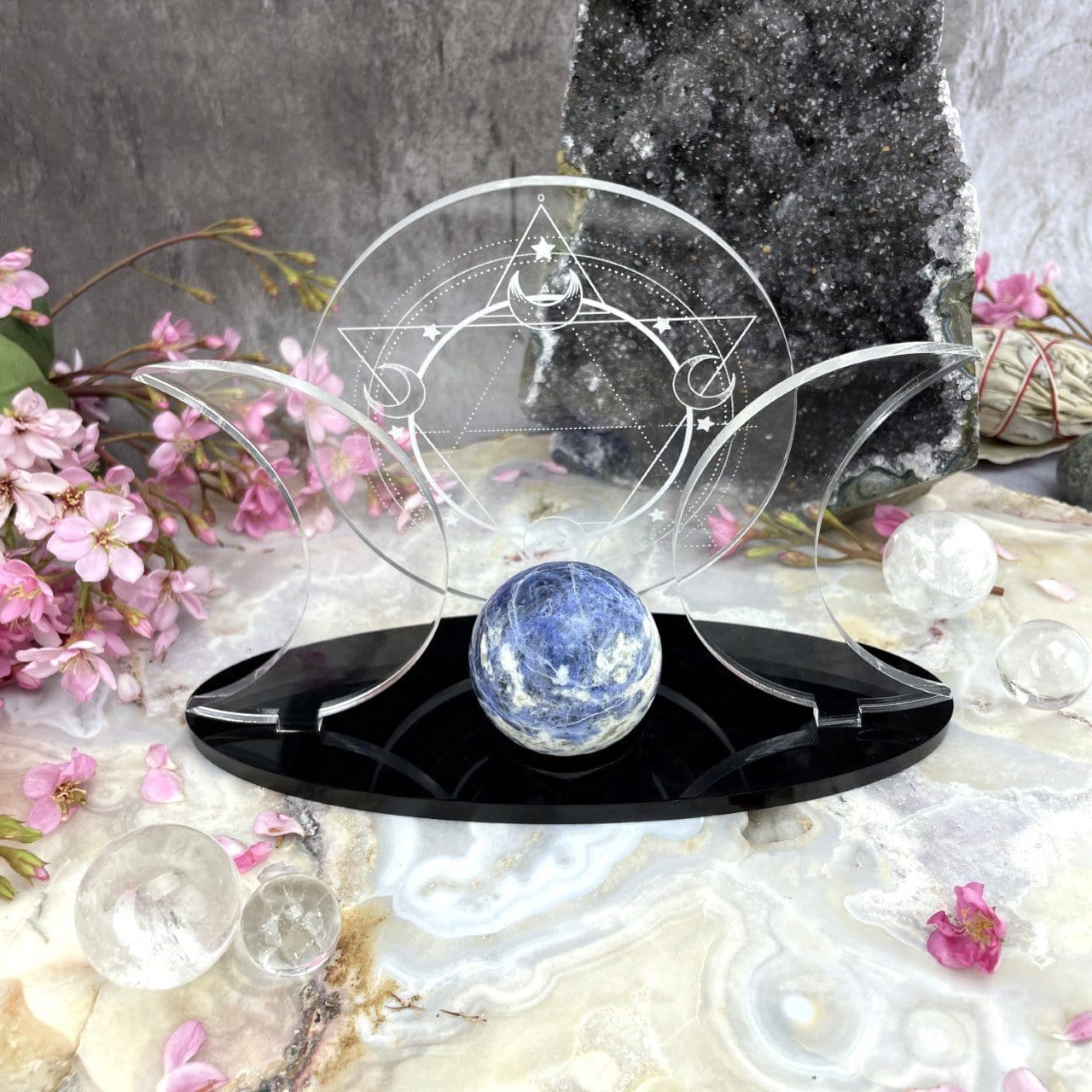 Front facing Acrylic Sphere Holder Sacred Geometry - 6 Pointed Star holding a sphere in an alter that consists of flowers and crystals.