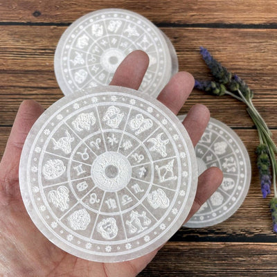 selenite zodiac engraved charging plate in hand for size reference