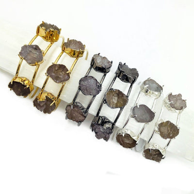 Druzy cuff bracelets in gold plating, silver plating and gunmetal plating on a white background.