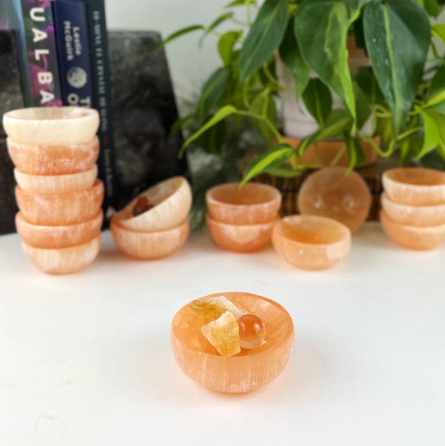 Orange Selenite Bowls in background and 1 in the front with small stones inside